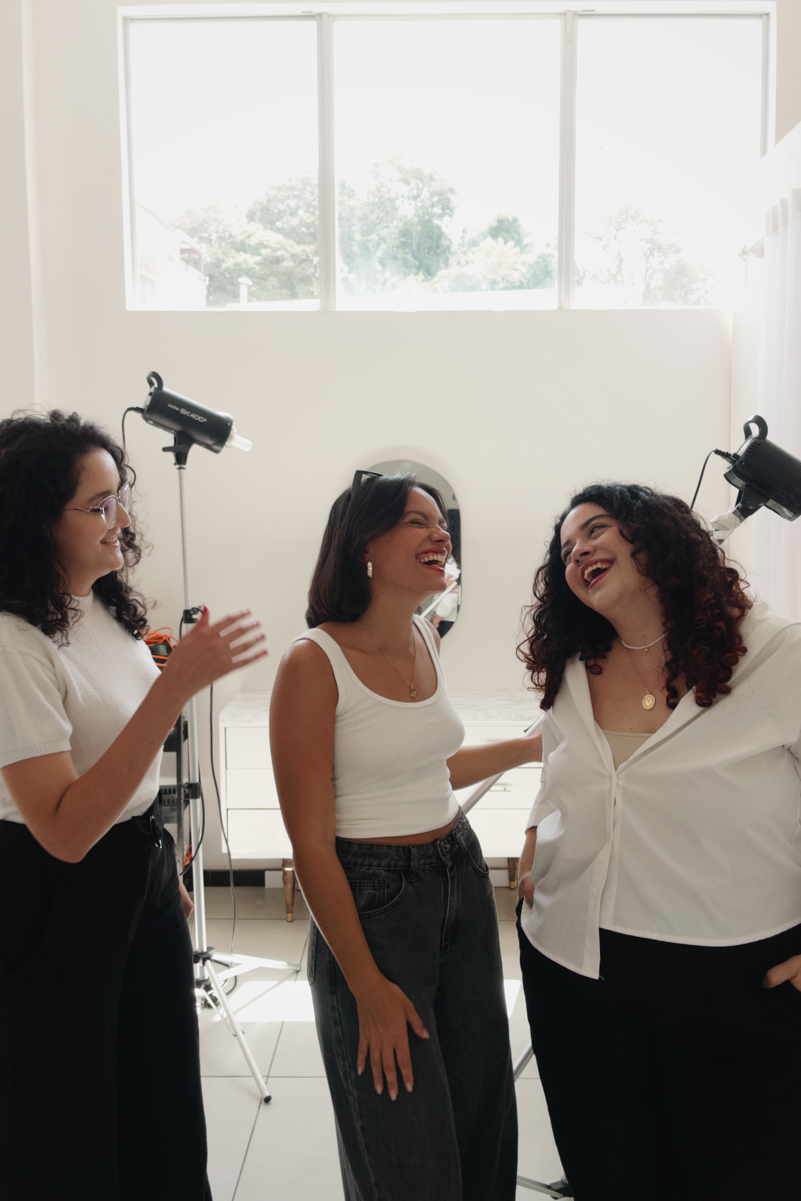 Produção de moda da Iconica: direção de cena leve e espontânea com modelos rindo durante o shooting comercial